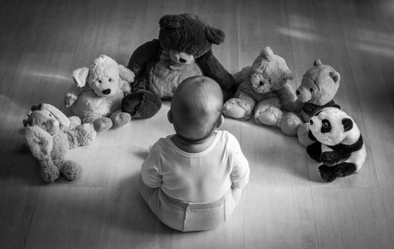 Baby Surrounded by Stuffed Animals