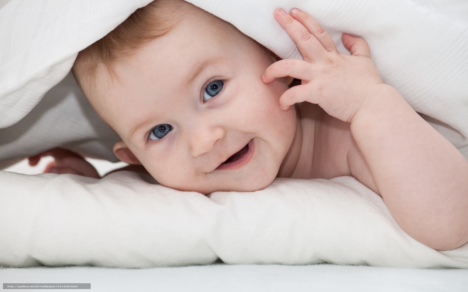 baby under blanket smiling