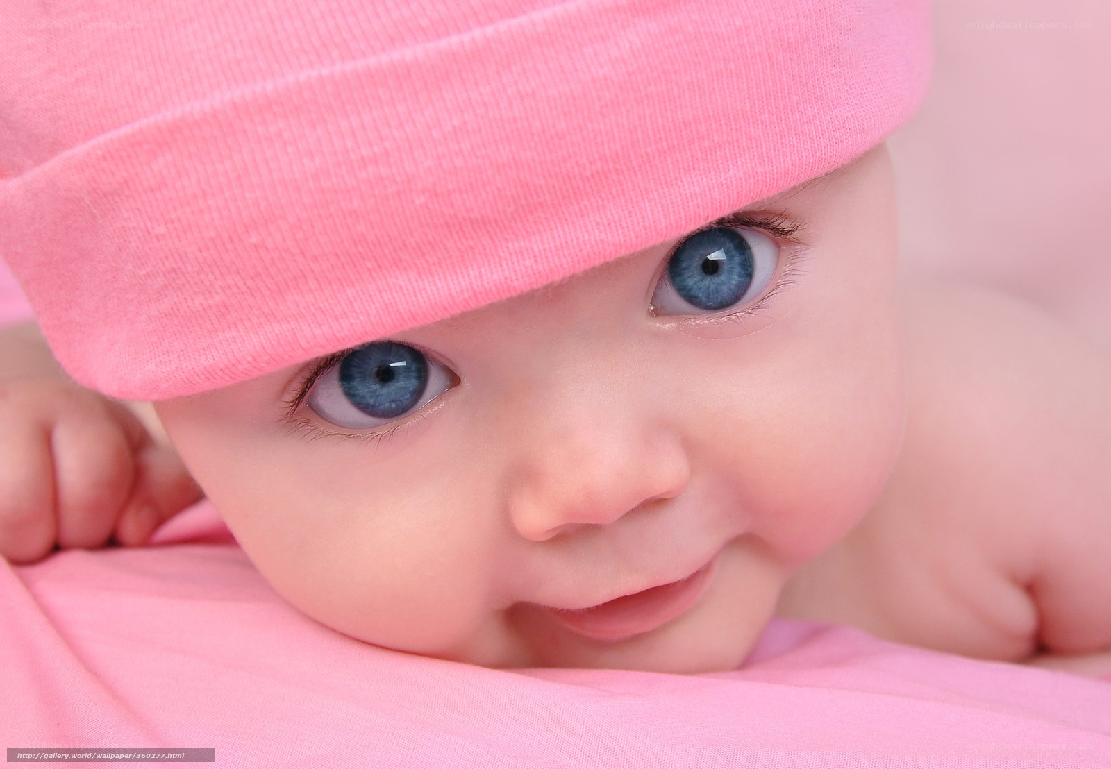Baby with blue eyes and pink hat