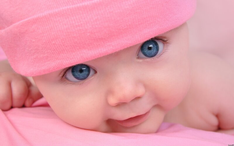 baby with blue eyes and pink hat