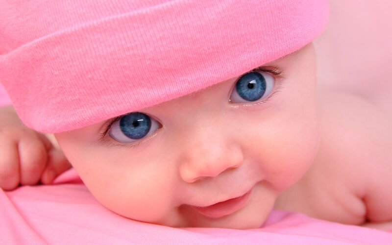 baby with blue eyes and pink hat