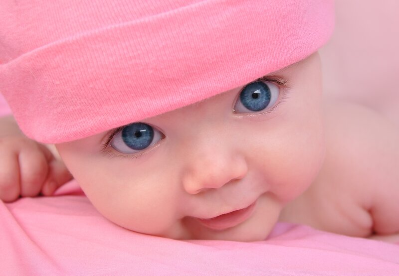 Baby with blue eyes and pink hat