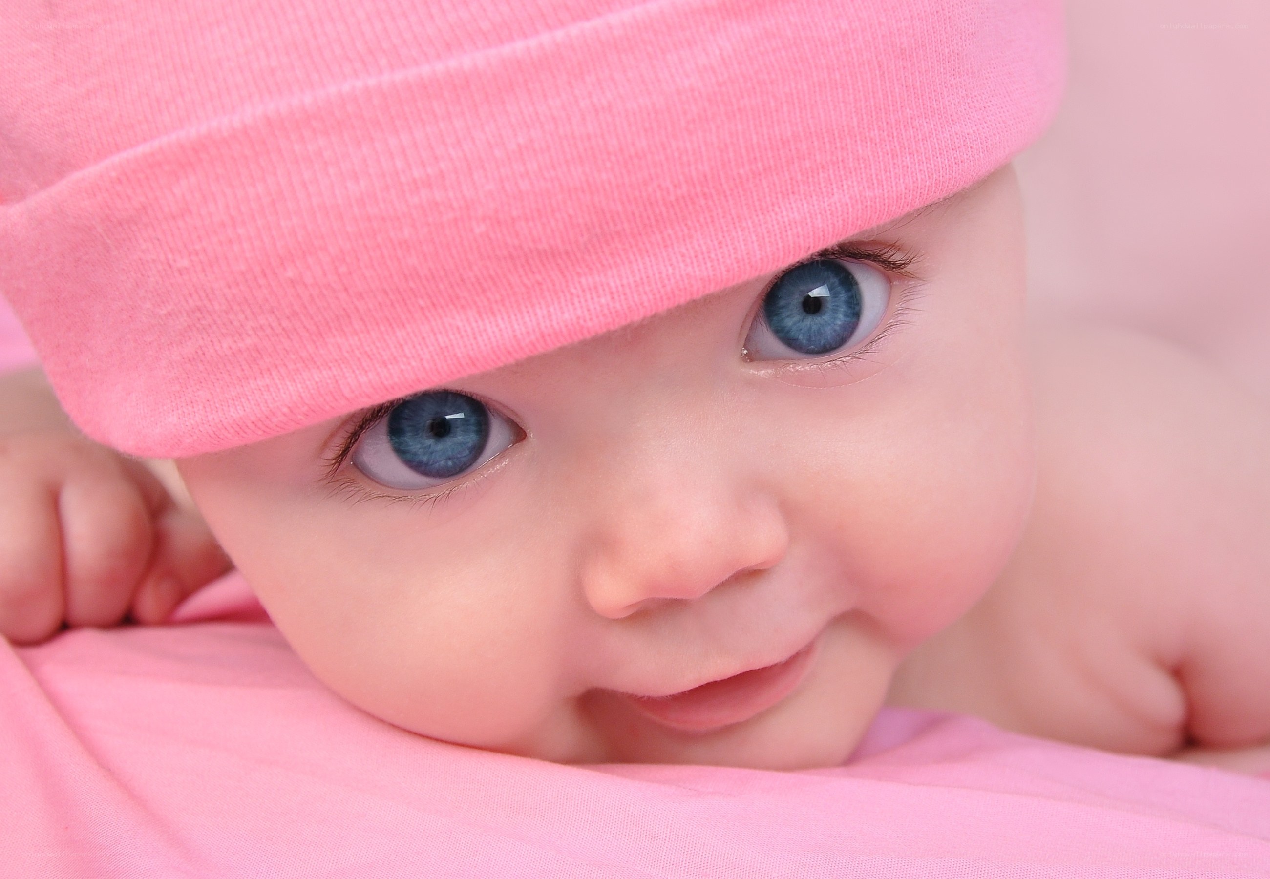 Baby with blue eyes and pink hat
