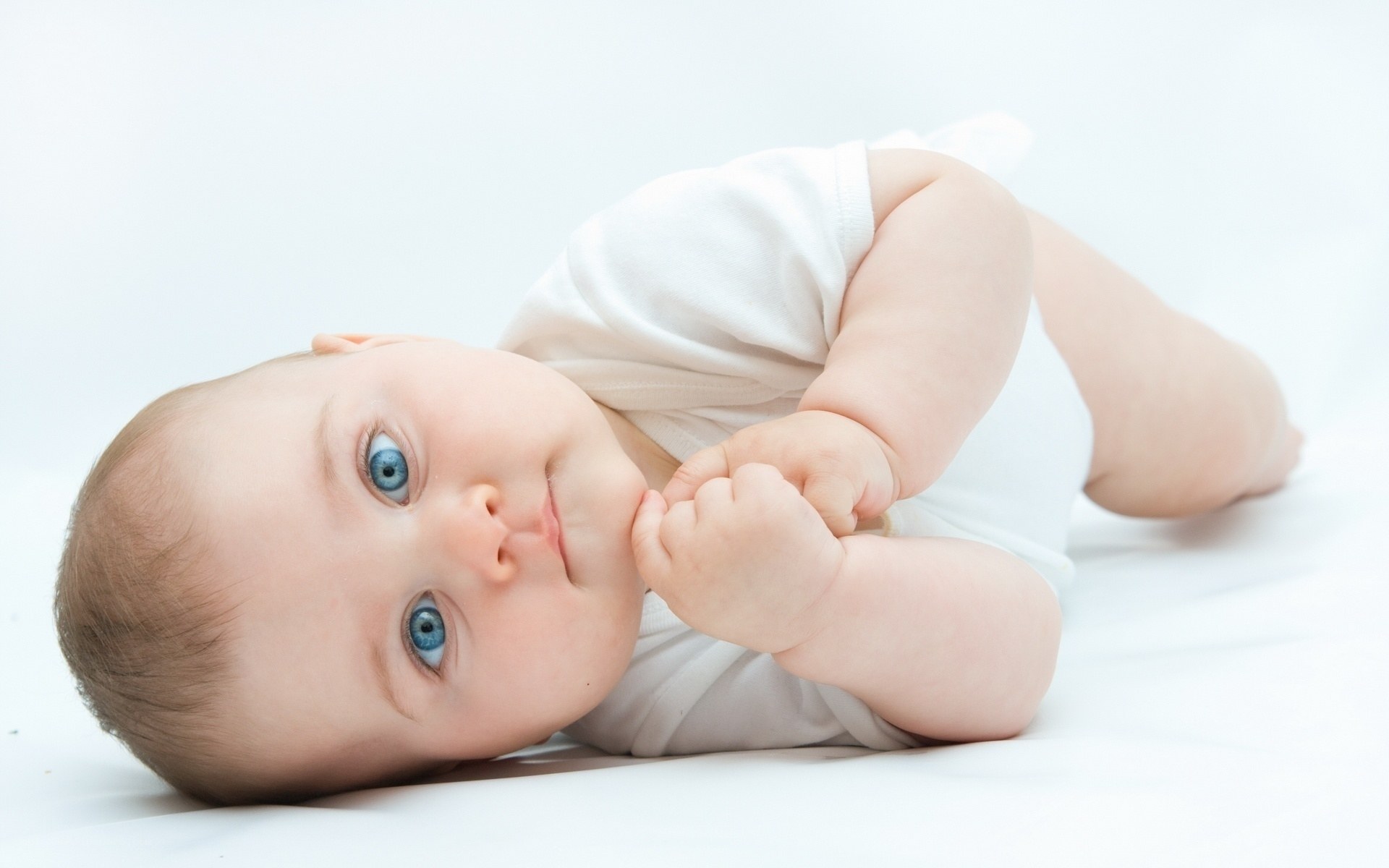 baby with blue eyes lying down