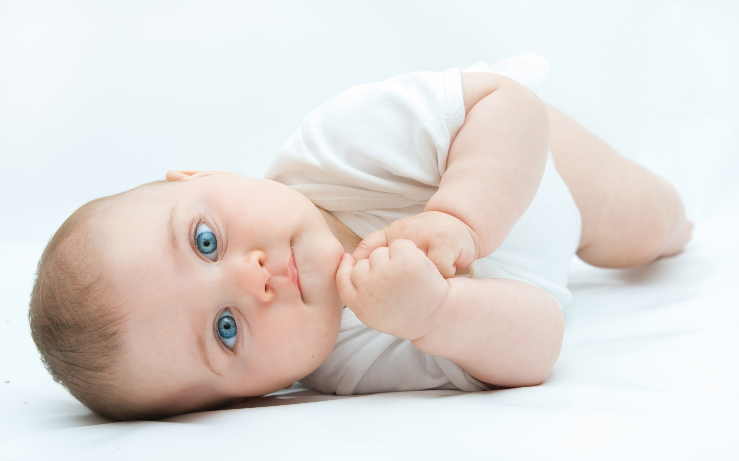 baby with blue eyes lying down