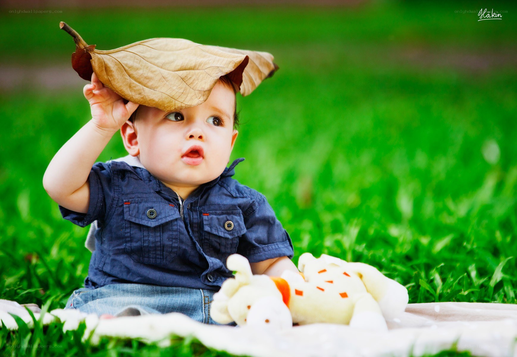 Baby with leaf hat on grass
