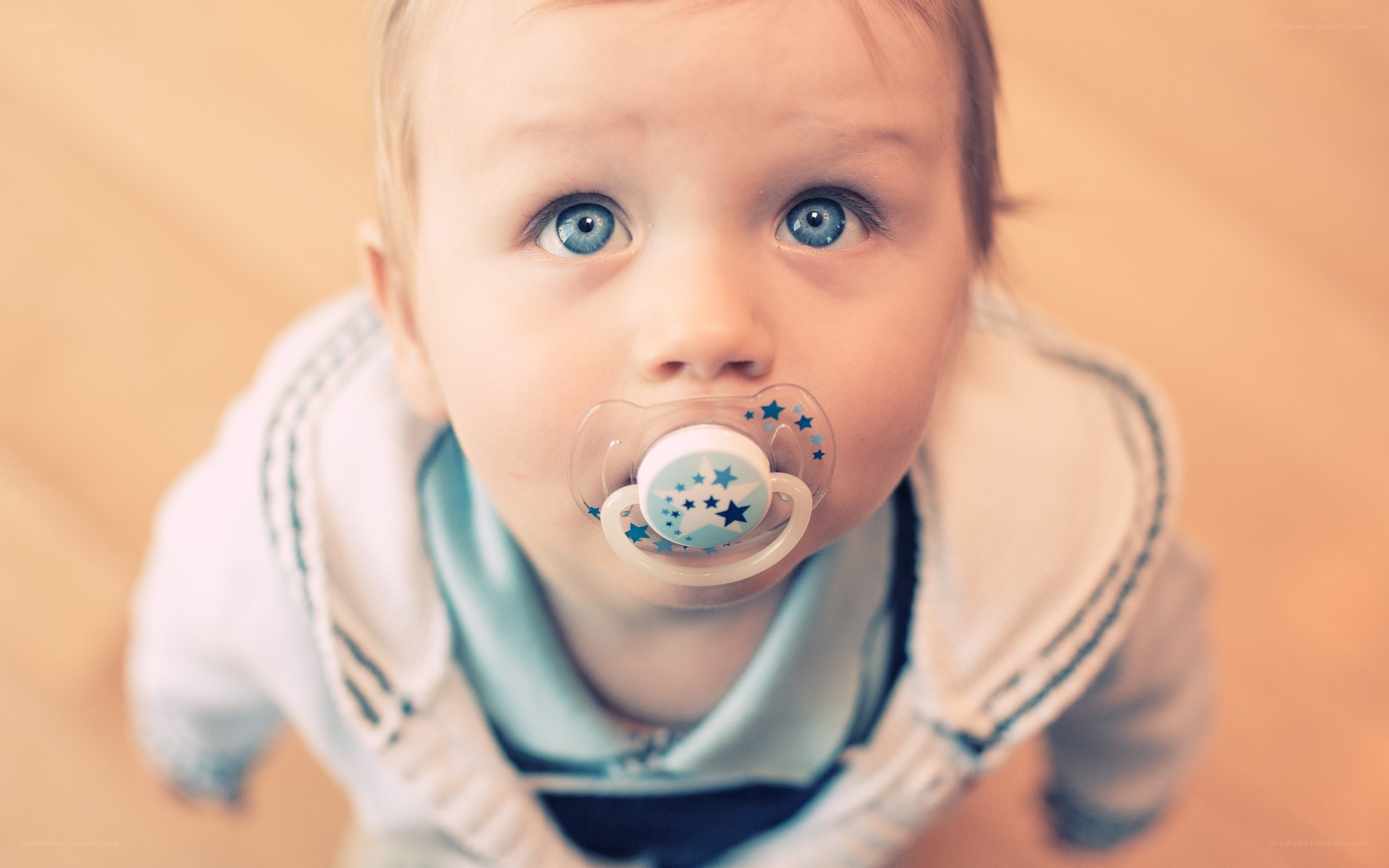 baby with pacifier looking up