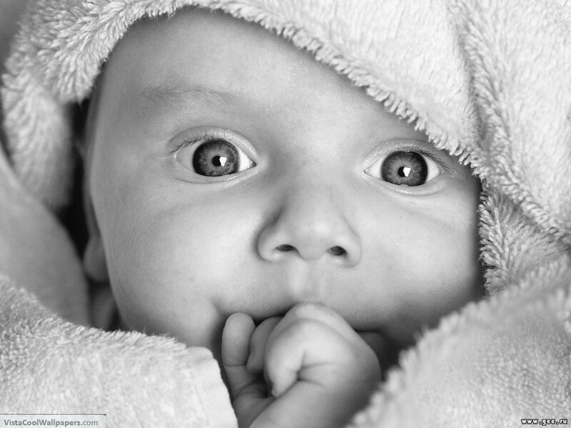 Baby with wide eyes in blanket