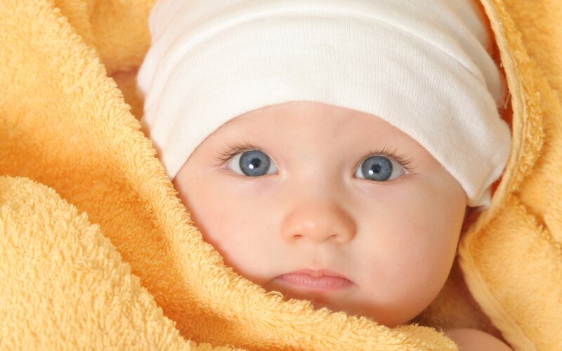 baby wrapped in yellow towel