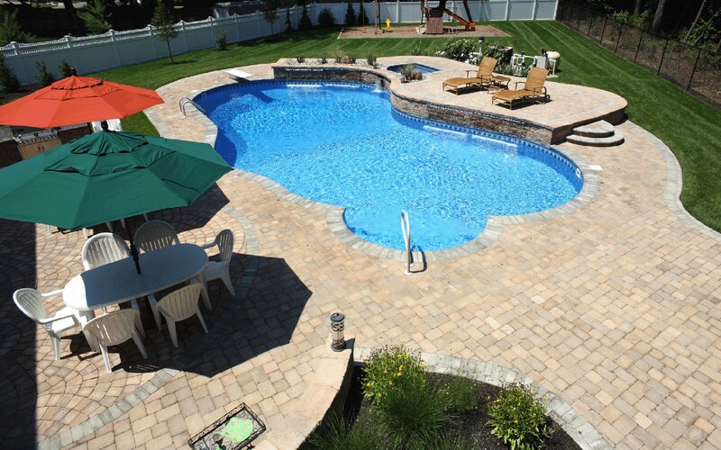 Backyard pool with patio and umbrellas