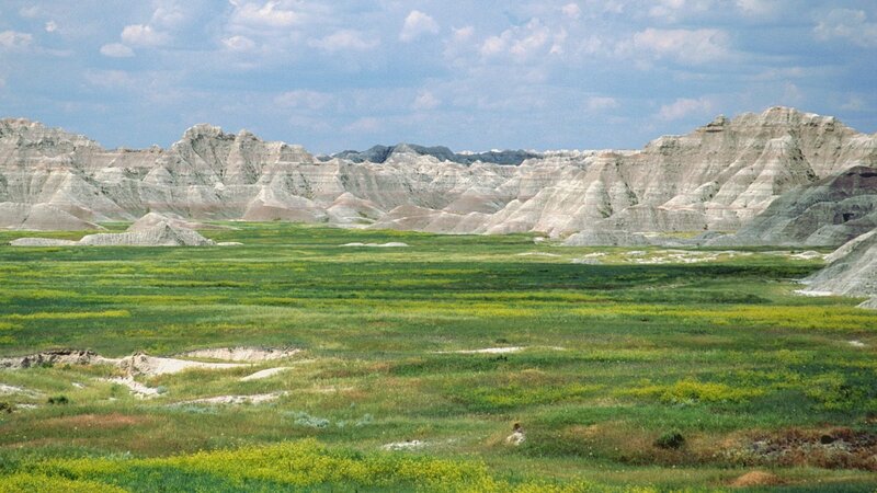 Badlands landscape with green fields
