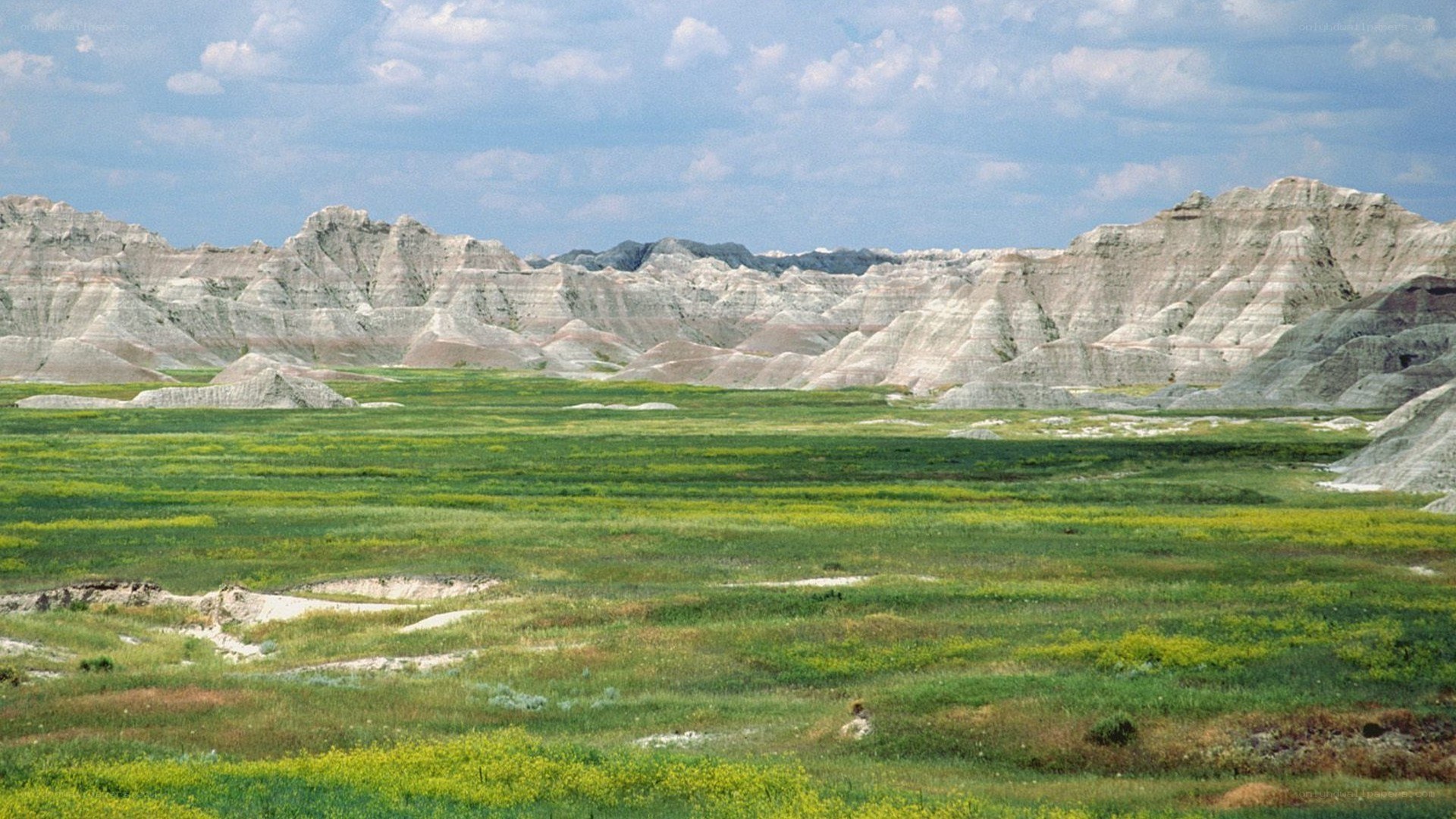 Badlands landscape with green fields