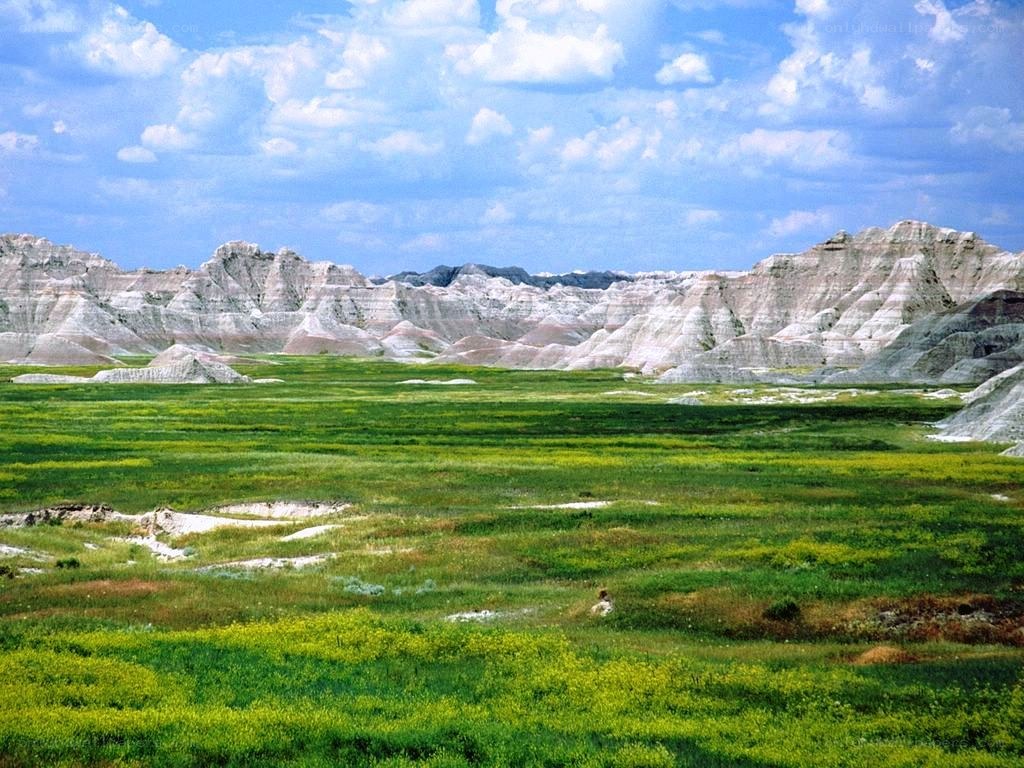 Badlands landscape with green fields