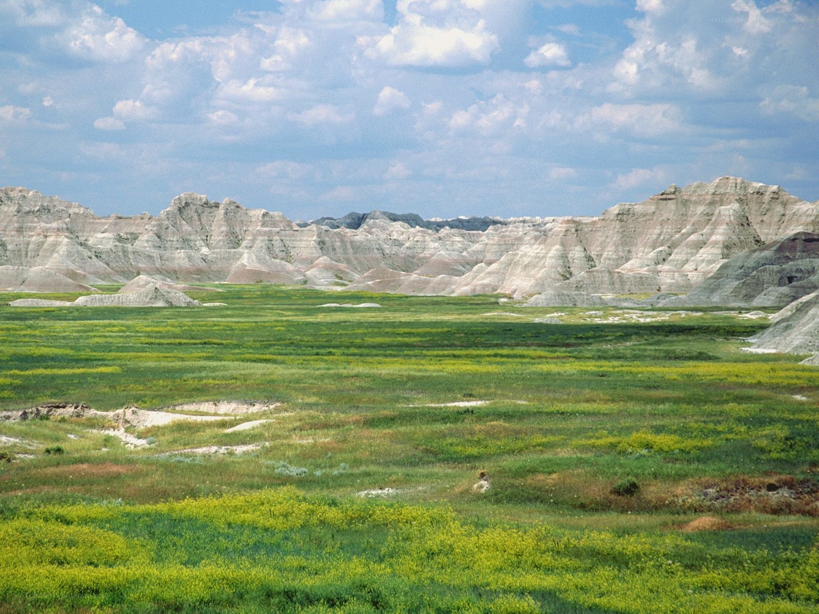 Badlands landscape with green fields