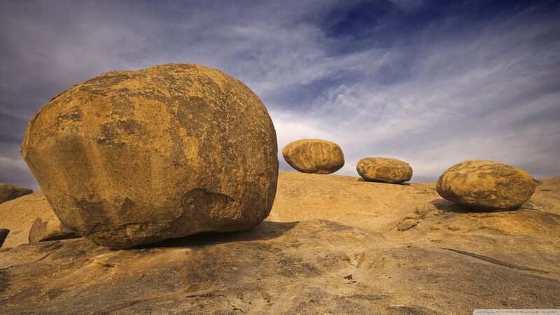 Balanced boulders under cloudy sky