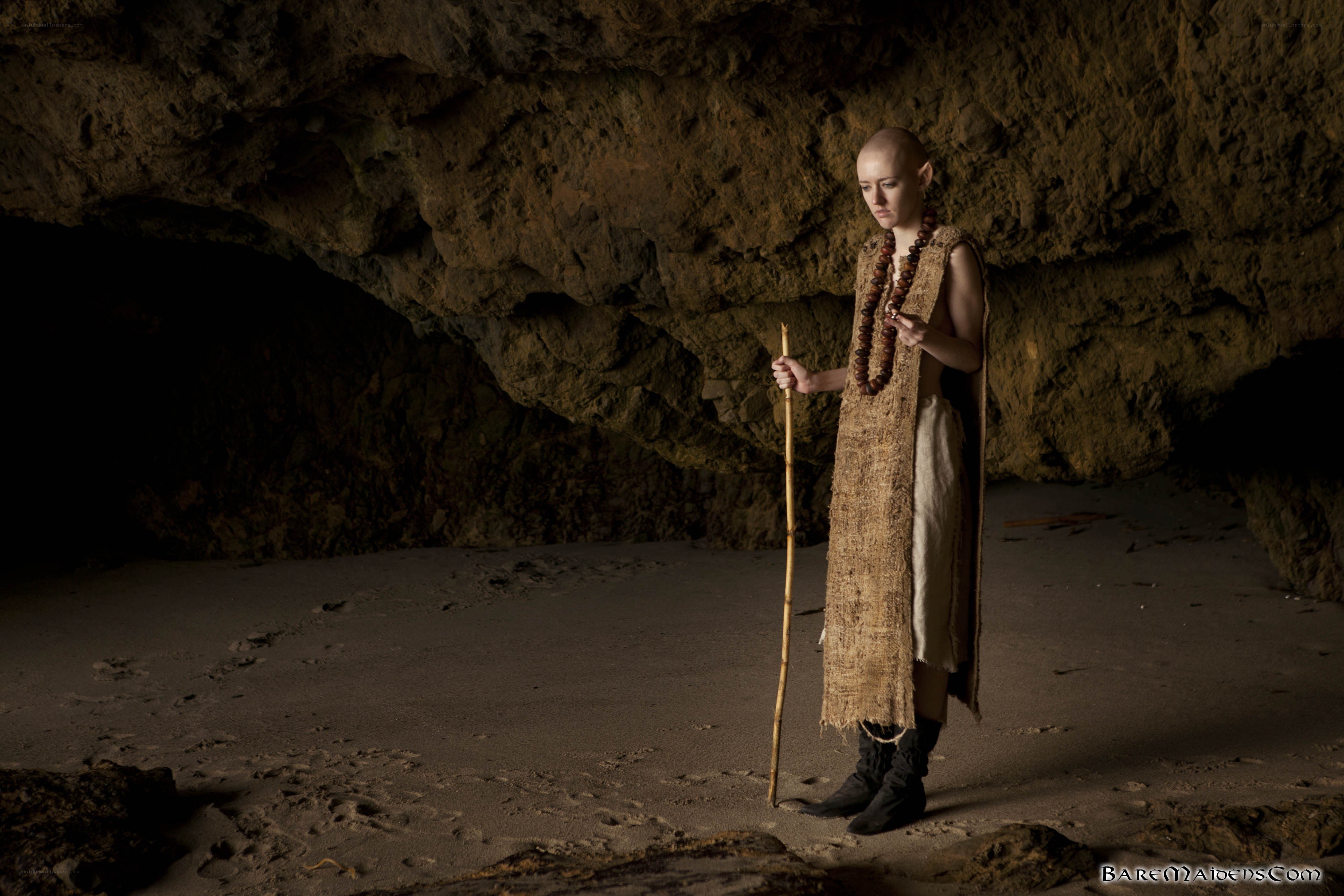 Bald figure in cave with staff