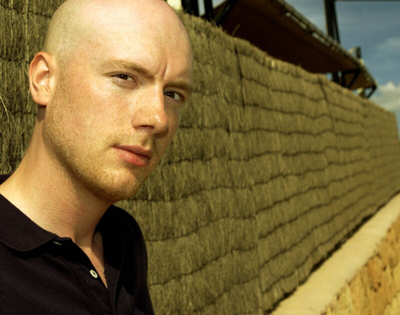bald man against straw wall