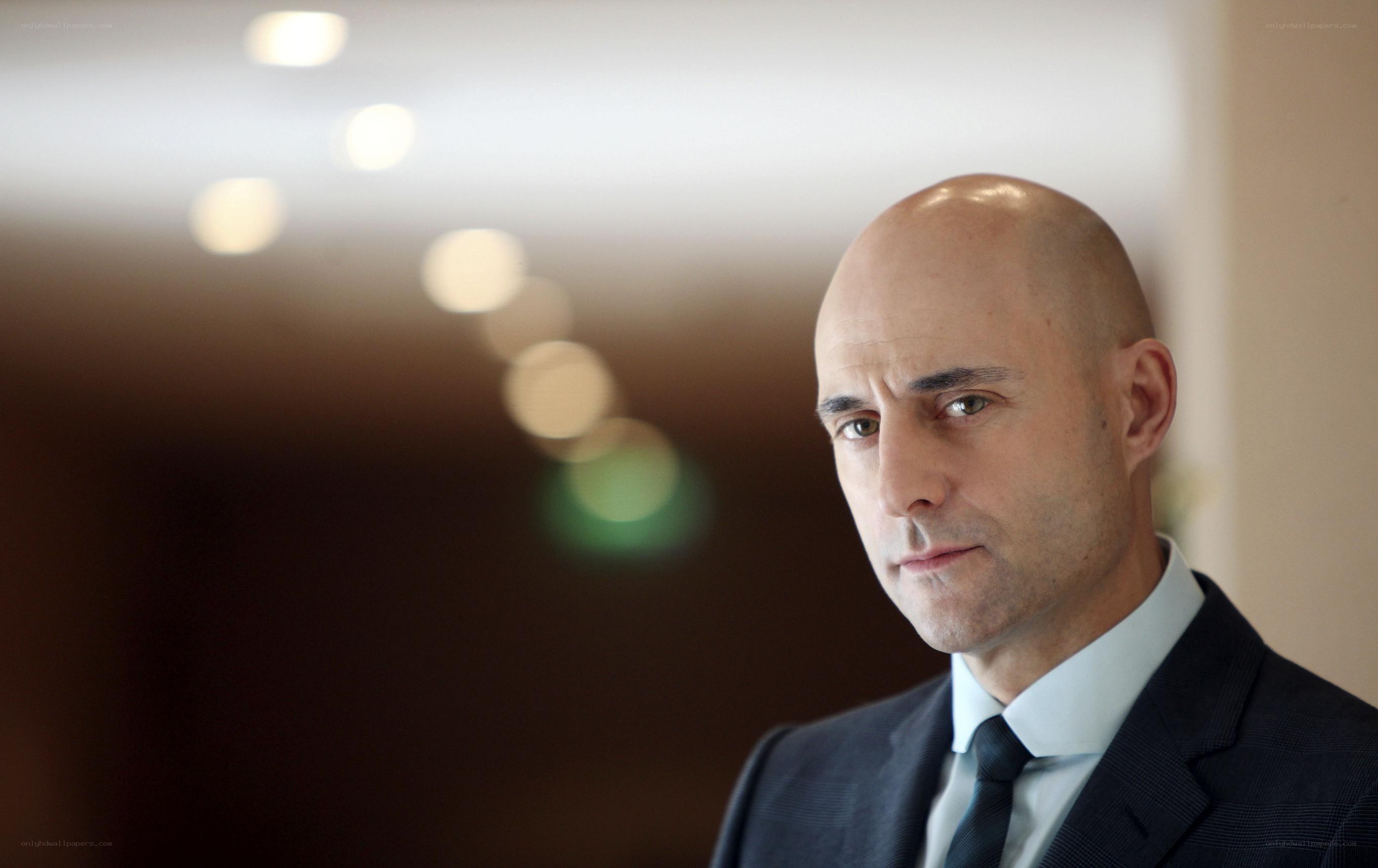 Bald man in suit looking at camera