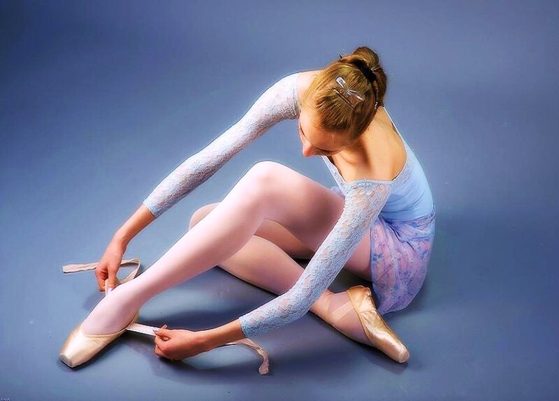 Ballerina tying pointe shoes