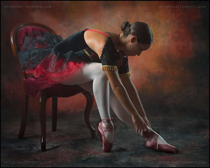 ballet dancer adjusting pointe shoes