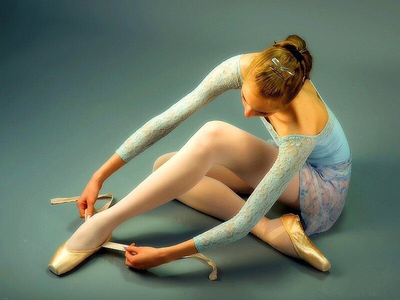 ballet dancer tying pointe shoes
