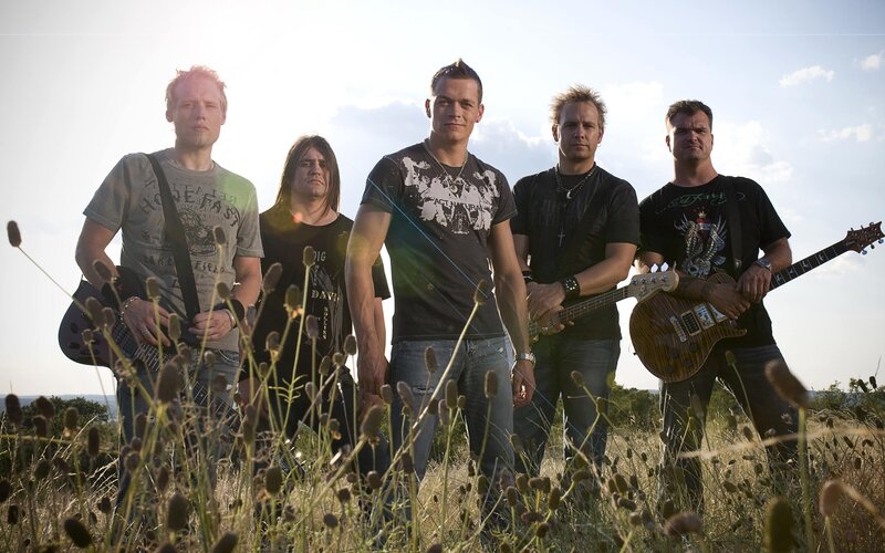 band in a field with guitars