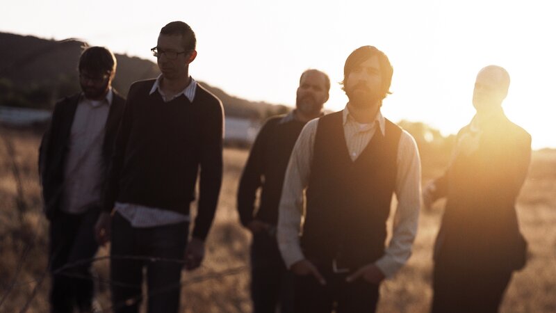 band in field at sunset