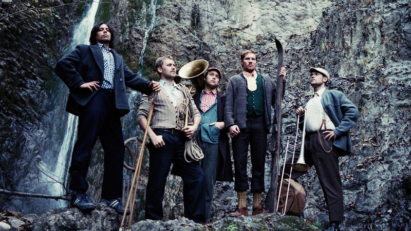 band in front of waterfall