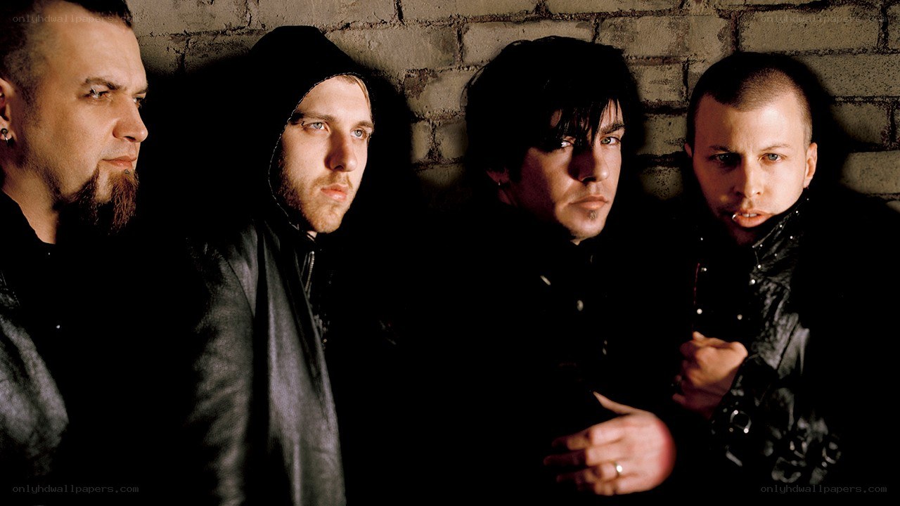 band members against brick wall