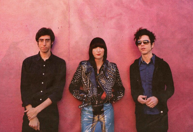 band members against pink wall
