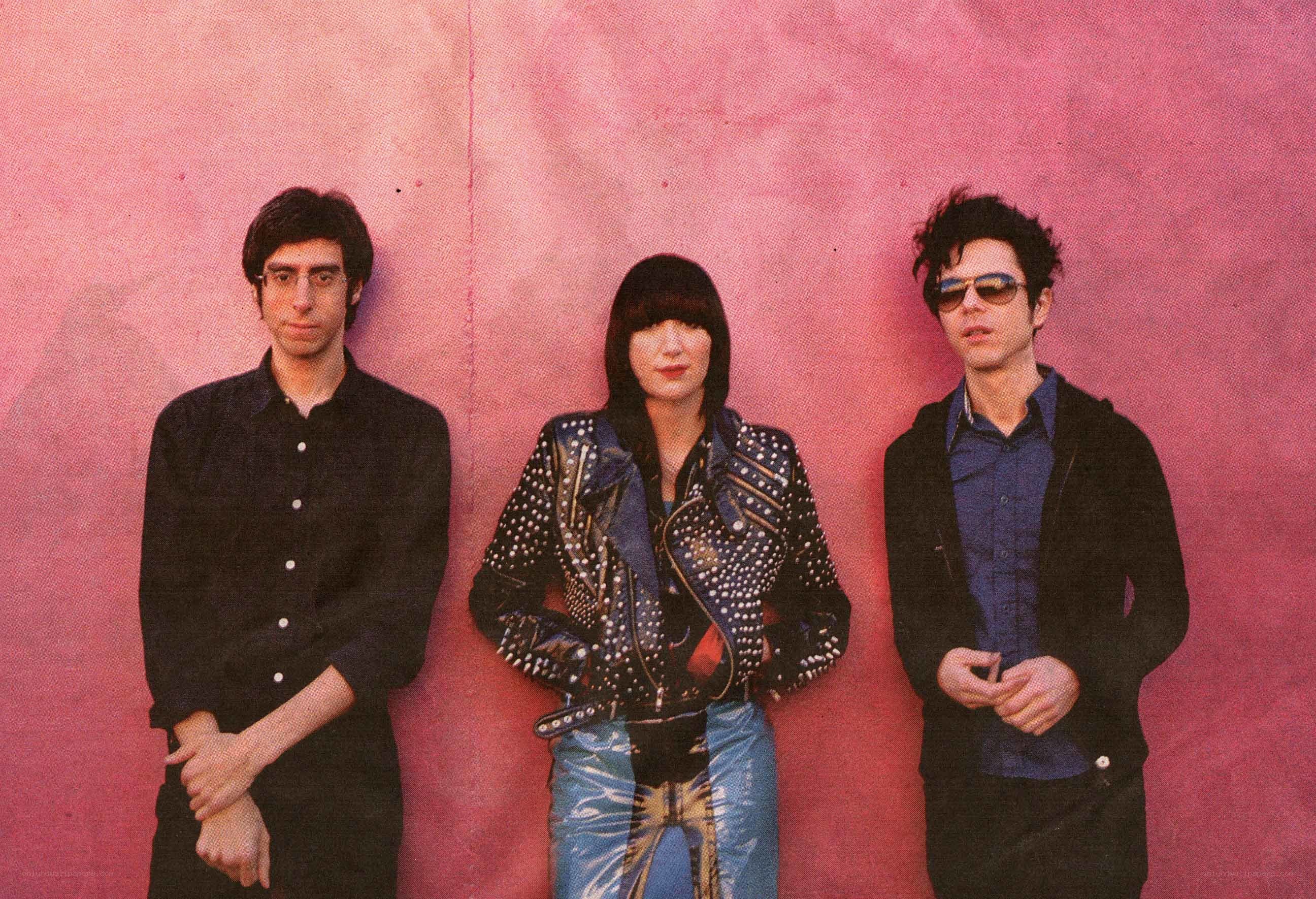 band members against pink wall