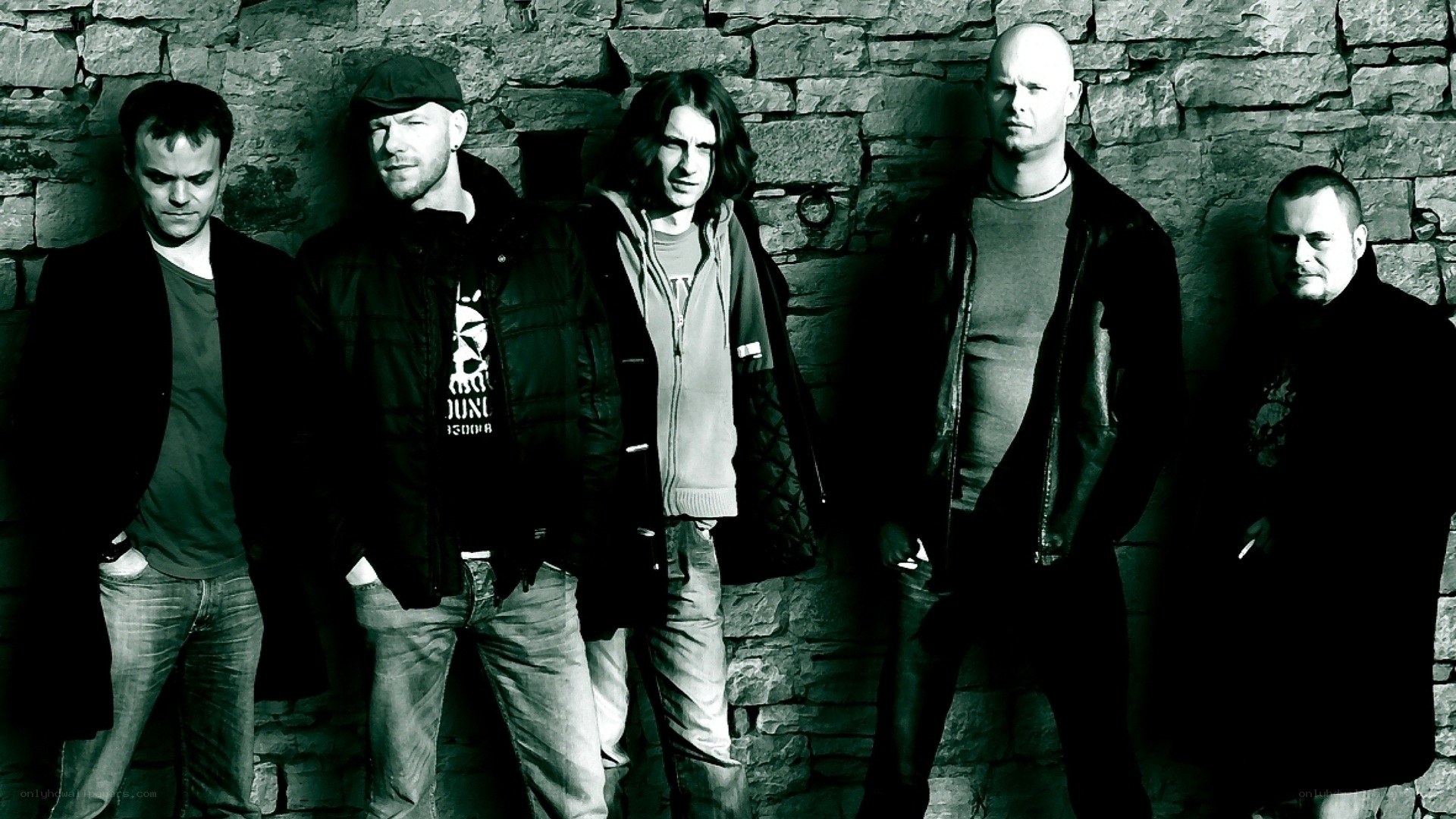band members against stone wall