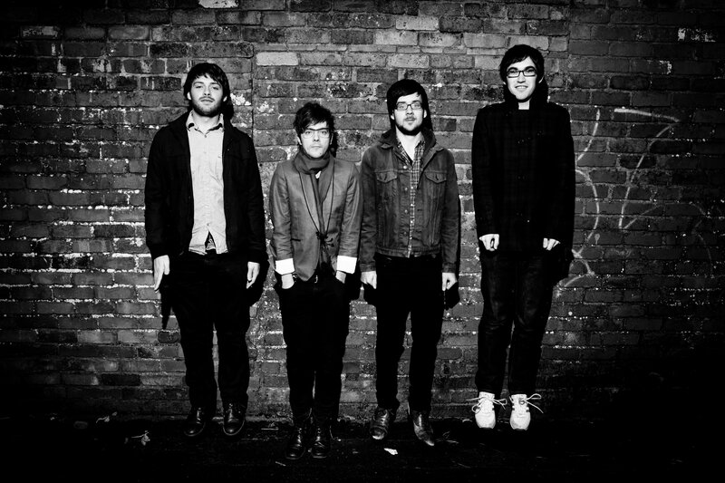 band members in front of brick wall