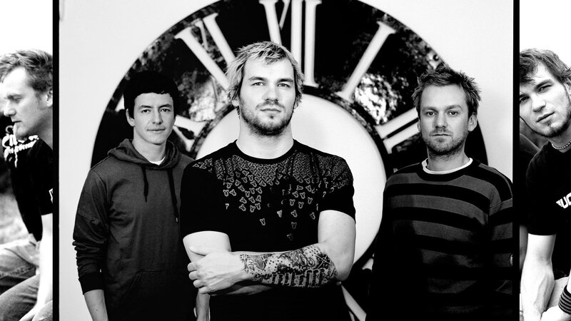 band members in front of clock