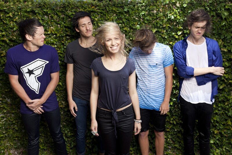 band members in front of green wall