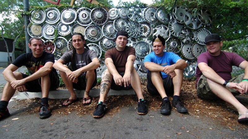 band members in front of hubcap art