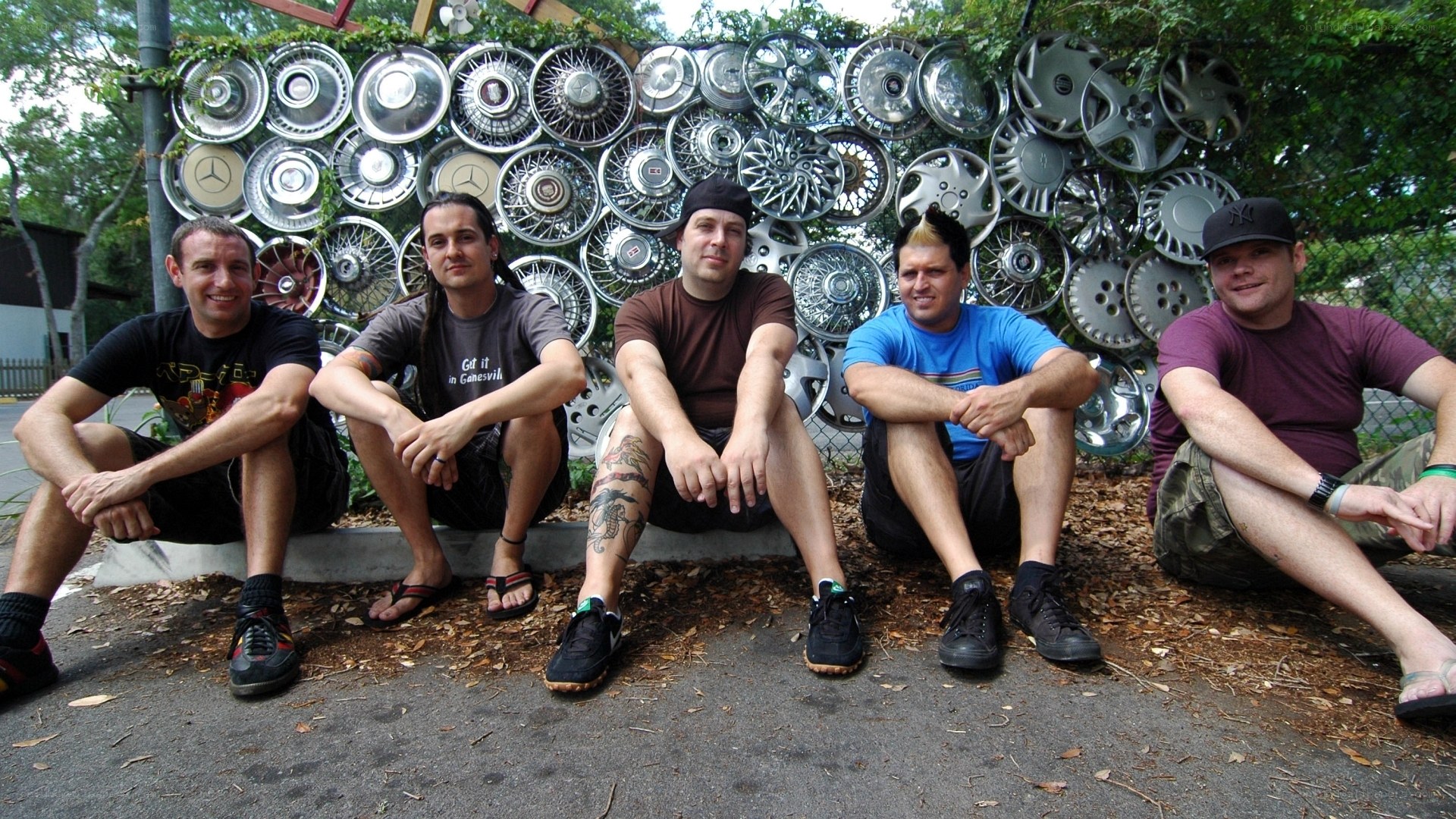 band members in front of hubcap art