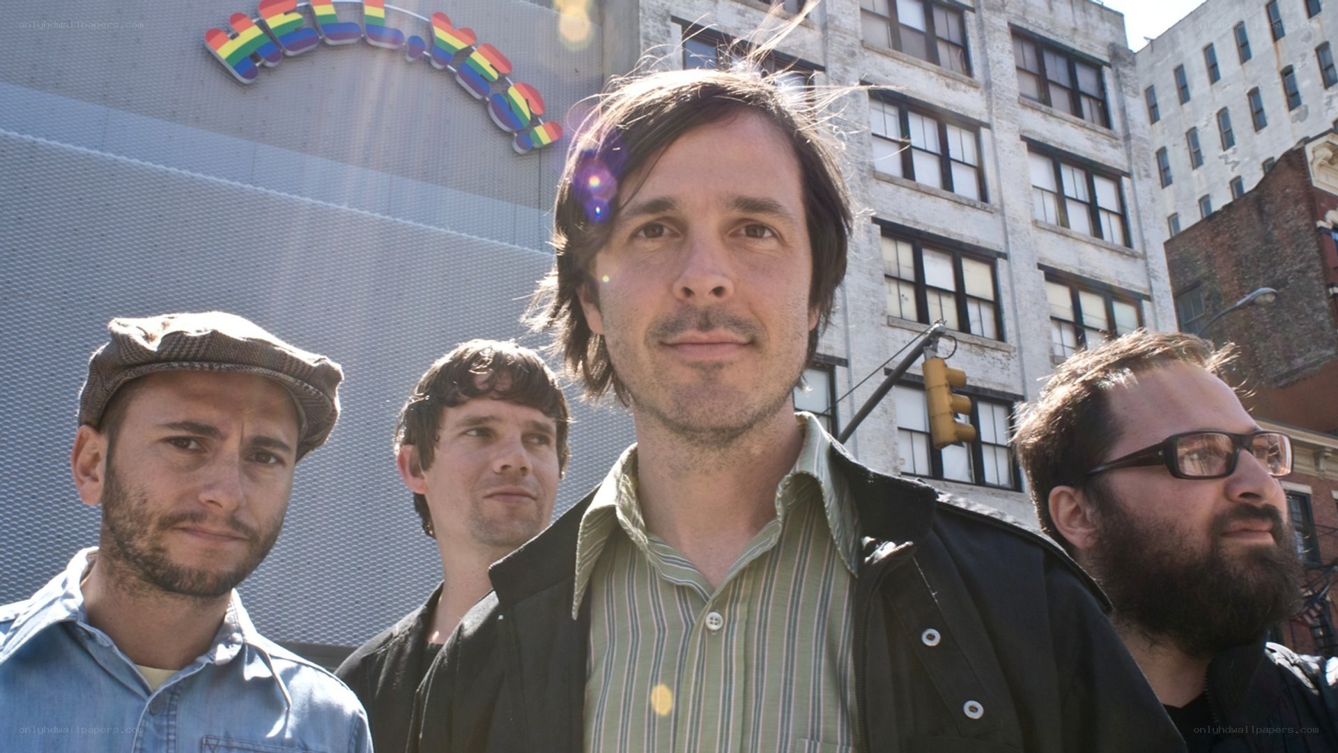band members in front of rainbow sign