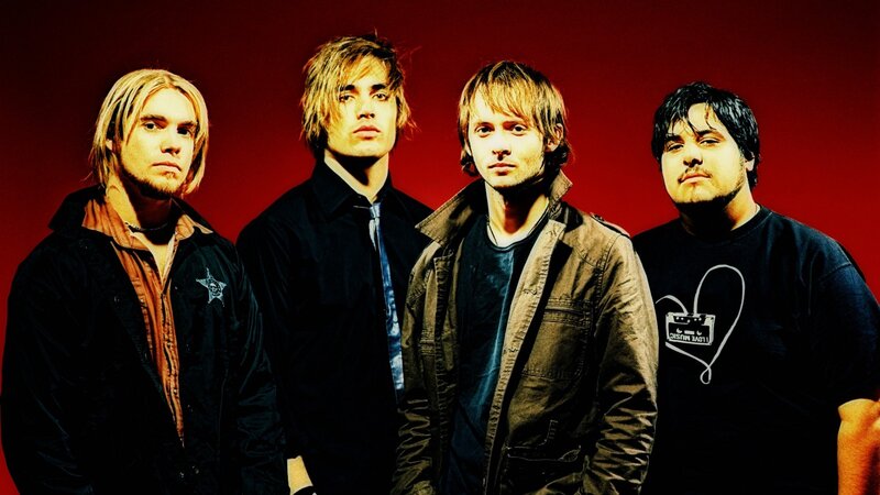 band members in front of red background