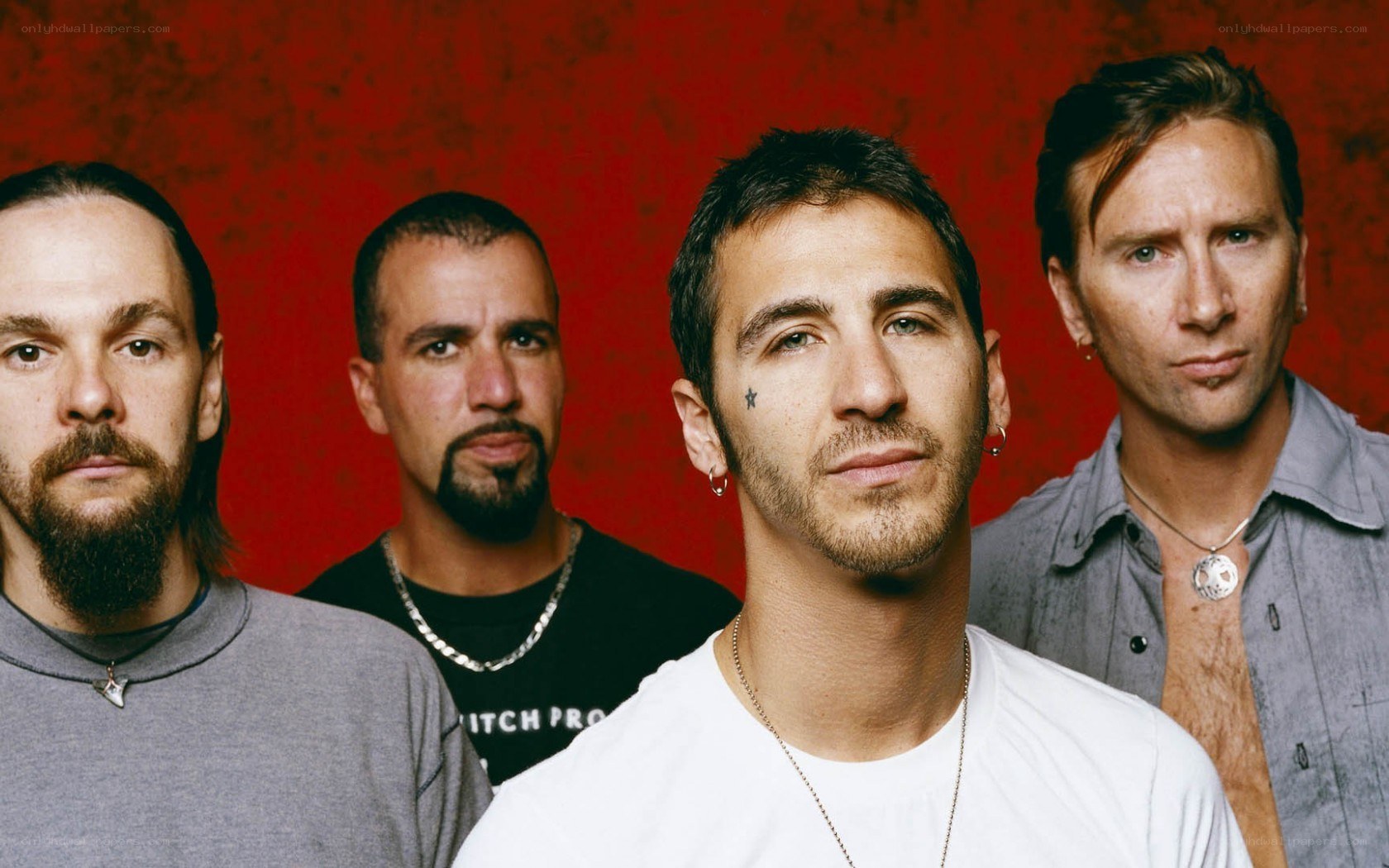 band members in front of red wall