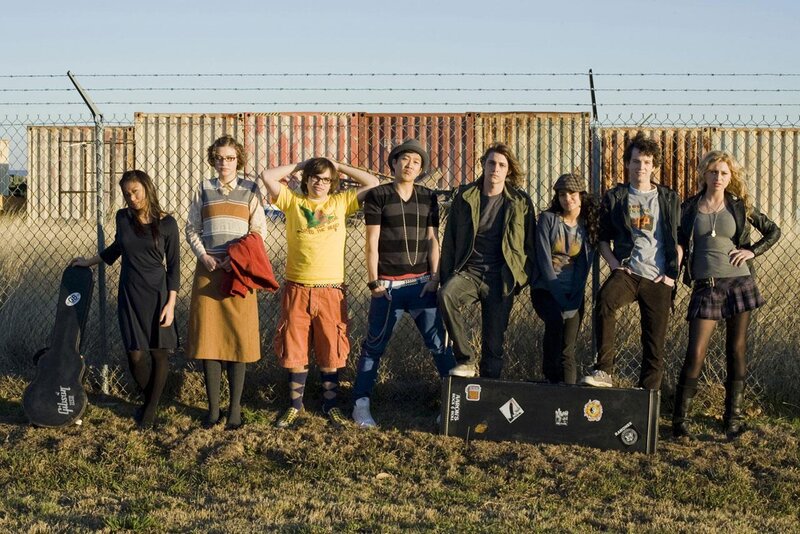 band members in front of shipping containers