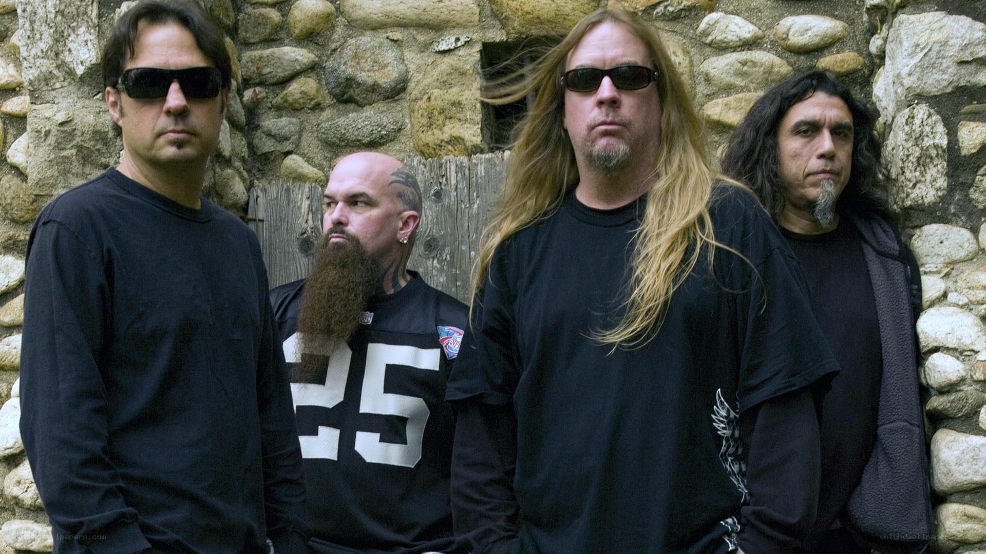 band members in front of stone wall