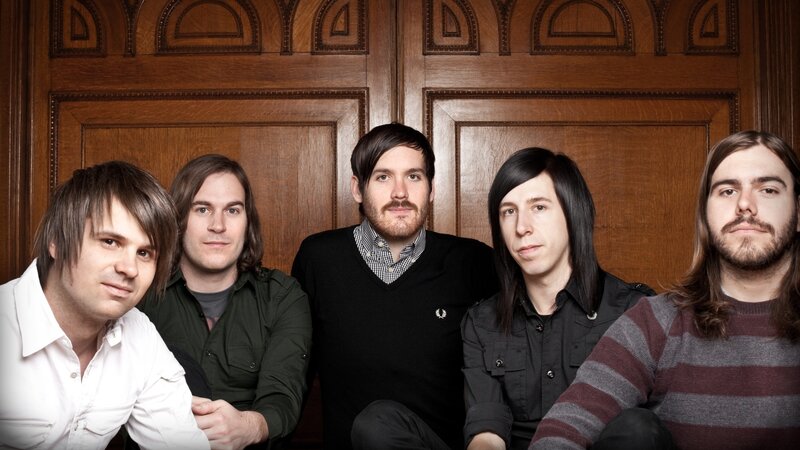 band members in front of wooden door
