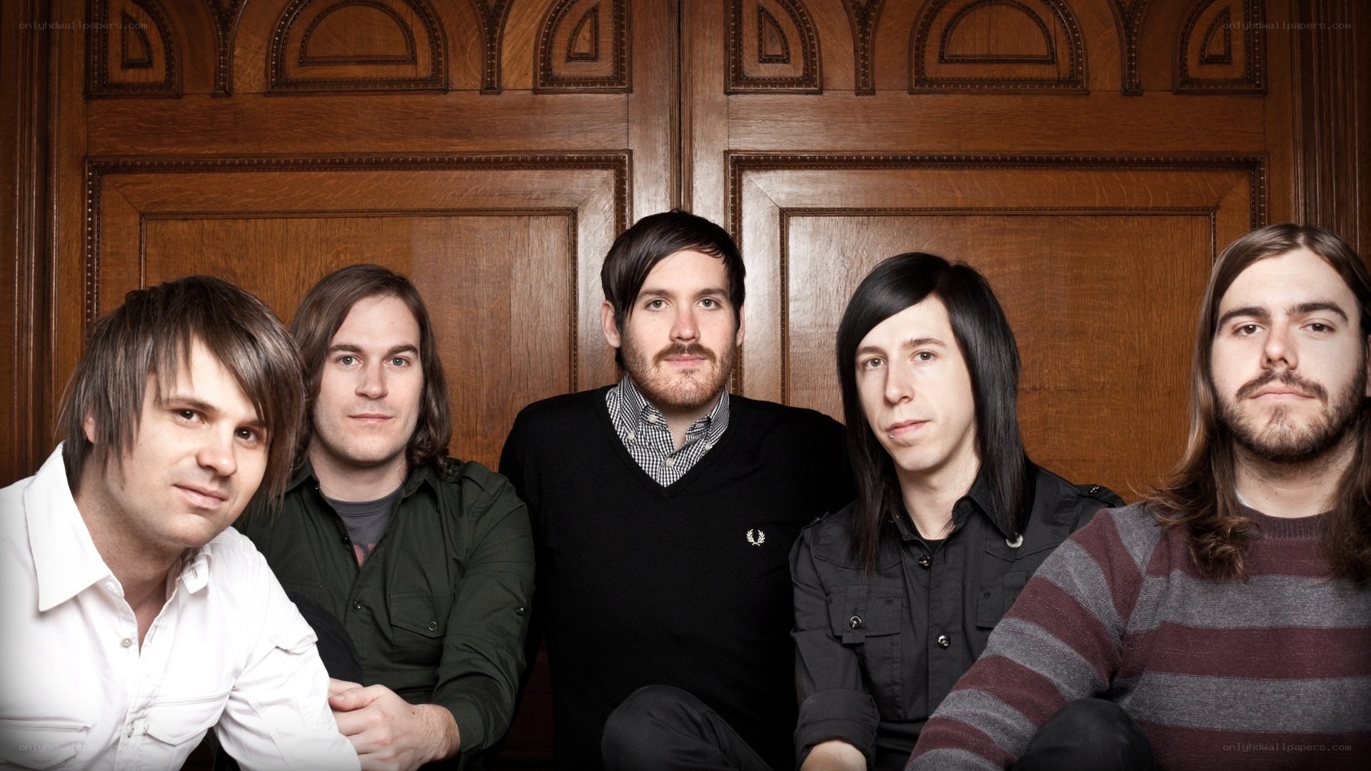 band members in front of wooden door
