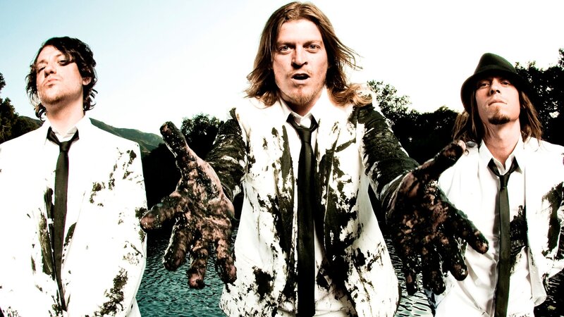 band members in muddy suits