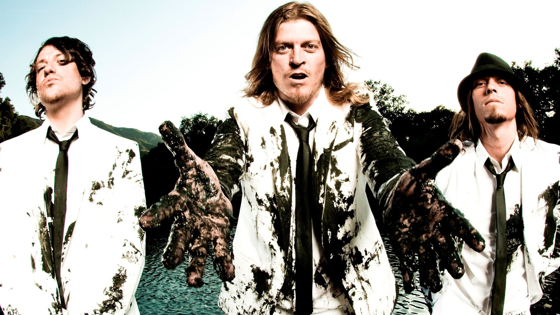 band members in muddy suits