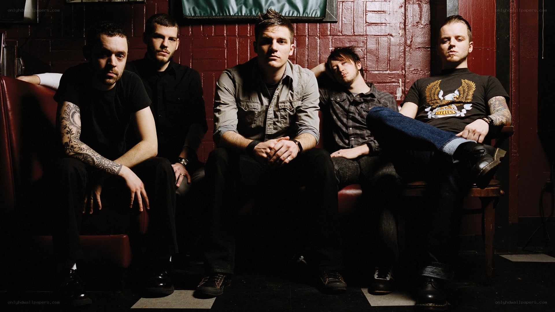 band members on a red couch
