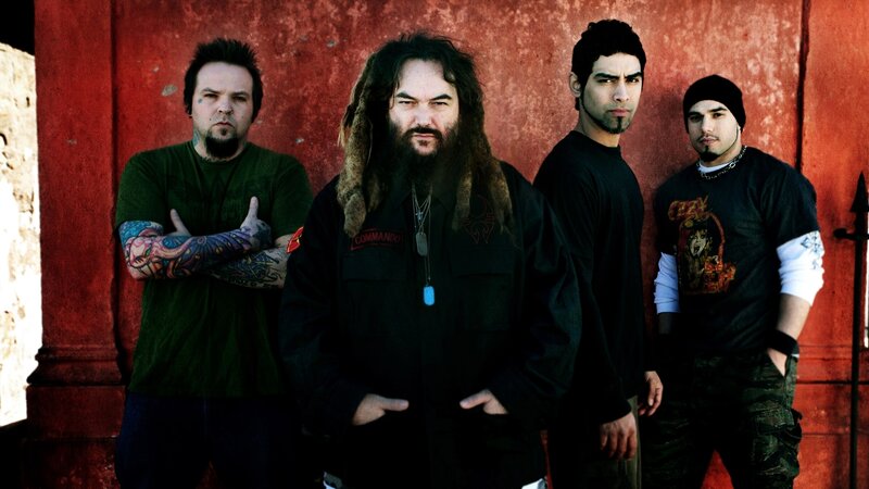 band members posing against red wall