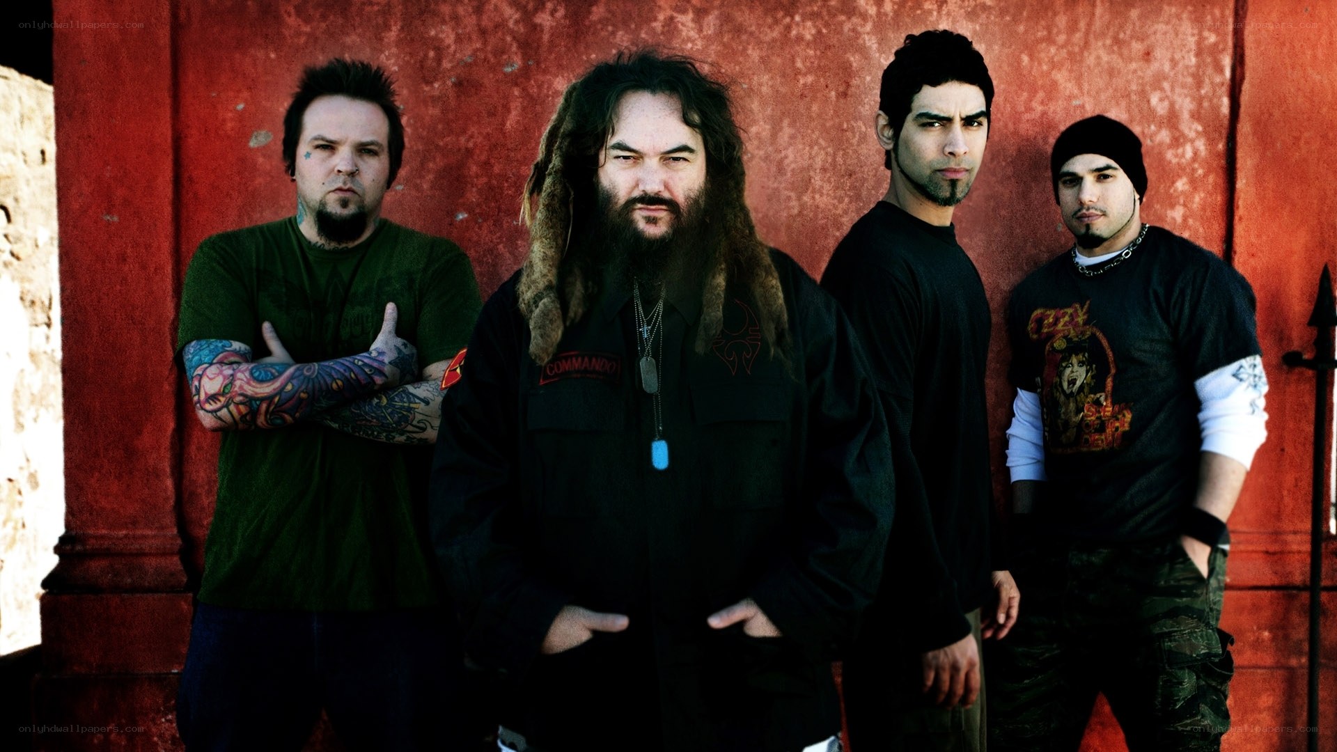 band members posing against red wall