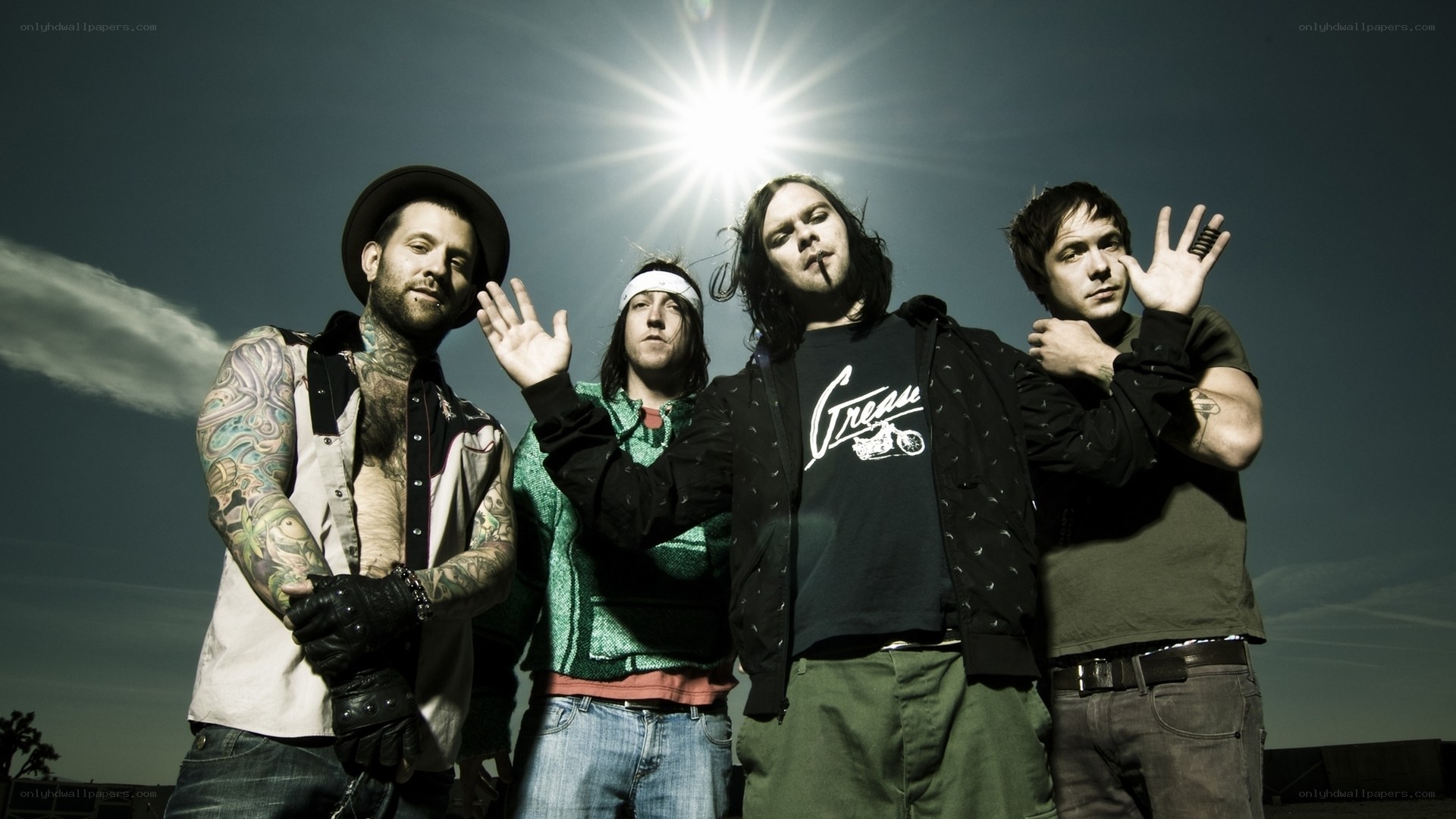 band members posing against sun